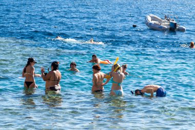 Sharm El Sheikh, Mısır - 1 Şubat 2020: Deniz kenarında yoğun bir yaz tatili. Güneşli bir günde insanlar denizde ve sahilde, güneşleniyorlar, yüzüyorlar.