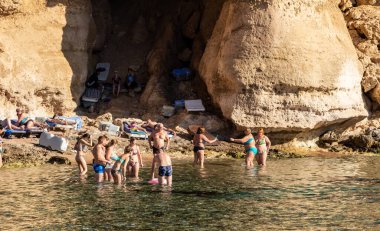 Sharm El Sheikh, Mısır - 1 Şubat 2020: Deniz kenarında yoğun bir yaz tatili. Güneşli bir günde insanlar denizde ve sahilde, güneşleniyorlar, yüzüyorlar.