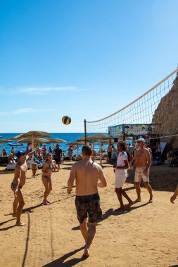 Sharm El Sheikh, Mısır - 4 Şubat 2020. İnsanlar plajda top ile voleybol oynuyorlar. Deniz kenarında yoğun bir yaz tatili. Güneşli bir gün.