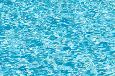 Su yüzeyi arka planı. Güneş yansımalı mavi havuz suyu. Havuzda su dalgaları.