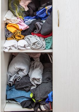 Askılardaki ve raflardaki eşyalar bir gardıropta katlanmıştı..