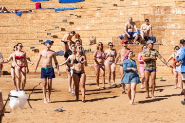 Sharm El Sheikh, Mısır - 10 Şubat 2020: kızlar ve kadınlar, erkekler deniz kıyısında dans ediyor. İnsanlar deniz sahilinde spor yapar. Deniz kenarında yoğun bir yaz tatili..