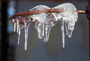 Sokakta güneşin altında buz saçakları asılı..