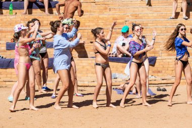 Sharm El Sheikh, Mısır - 10 Şubat 2020: kızlar ve kadınlar, erkekler deniz kıyısında dans ediyor. İnsanlar deniz sahilinde spor yapar. Deniz kenarında yoğun bir yaz tatili..