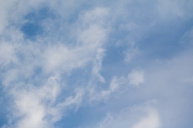 Mavi gökyüzünde beyaz bulutlar. Gökyüzünde yüzen bulutların arkaplanı, tuhaf hatları olan bulutların tanımlanabilir bir rahatlama biçimini oluşturan materyalin dokusuyla doludur..