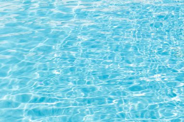 Su yüzeyi arka planı. Güneş yansımalı mavi havuz suyu. Havuzda su dalgaları.