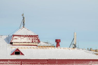 Kışın evin çatısında, mavi gökyüzüne karşı..