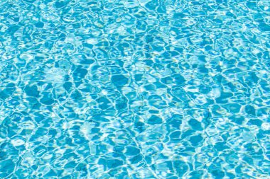 Su yüzeyi arka planı. Güneş yansımalı mavi havuz suyu. Havuzda su dalgaları.