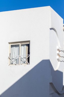 Mimari tarzda çok az bir geçmişi var. Mavi gökyüzüne karşı beyaz duvarlar.