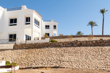 Sharm el Sheikh, Mısır - 28 Ocak 2020: Mısır 'da beyaz villalar. Deniz, havuz, mavi gökyüzünün arka planında plaj. Lüks evlerde deniz tatili.