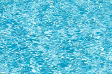 Su yüzeyi arka planı. Güneş yansımalı mavi havuz suyu. Havuzda su dalgaları.