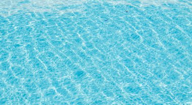 Su yüzeyi arka planı. Güneş yansımalı mavi havuz suyu. Havuzda su dalgaları.
