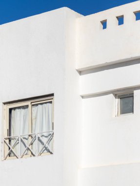 Mimari tarzda çok az bir geçmişi var. Mavi gökyüzüne karşı beyaz duvarlar.