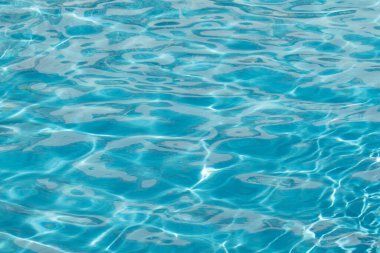 Su yüzeyi arka planı. Güneş yansımalı mavi havuz suyu. Havuzda su dalgaları.