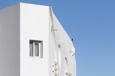 Mimari tarzda çok az bir geçmişi var. Mavi gökyüzüne karşı beyaz duvarlar.