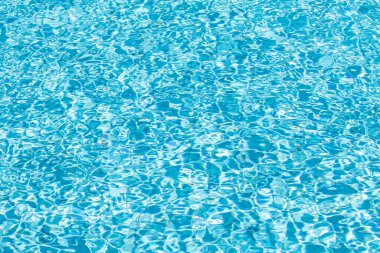 Su yüzeyi arka planı. Güneş yansımalı mavi havuz suyu. Havuzda su dalgaları.