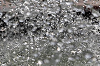 Karanlık arka planda su damlaları sınırlıdır. Kara zeminde donarak havaya düşen su damlaları..