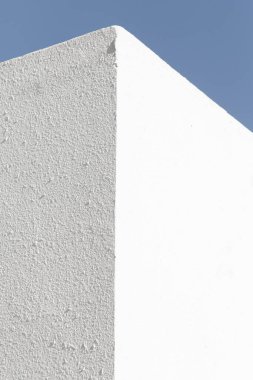 Mimari tarzda çok az bir geçmişi var. Mavi gökyüzüne karşı beyaz duvarlar.