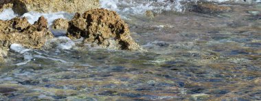 Taşlarda deniz dalgası, köpüklü sprey, yaz manzarası..