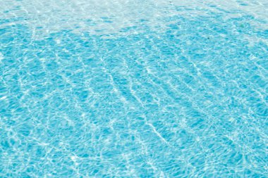 Su yüzeyi arka planı. Güneş yansımalı mavi havuz suyu. Havuzda su dalgaları.