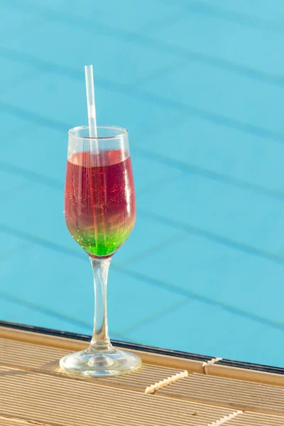 玻璃杯 鸡尾酒与稻草在模糊的游泳池背景 在一个自然模糊的度假胜地 在游泳池边喝着冷饮 还有暑假 放松的空间 — 图库照片