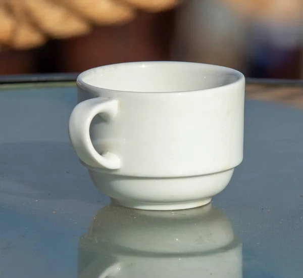 在街上的桌子上摆放着一个手工茶碟的白色茶杯 — 图库照片