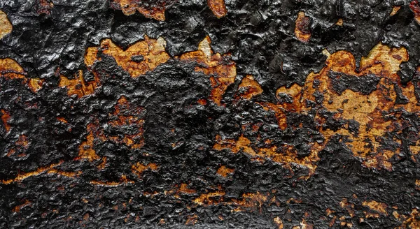 Black texture with metal ash as a background. The surface of the pan is charred.