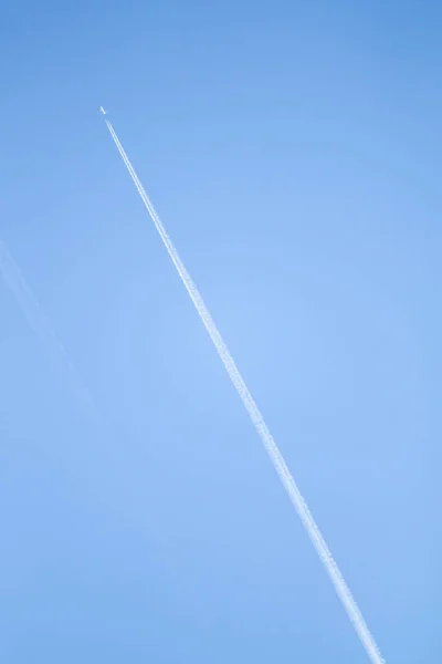 青い空の飛行機から白いトラック 澄んだ青空に翼のある旅客機の軌跡 — ストック写真
