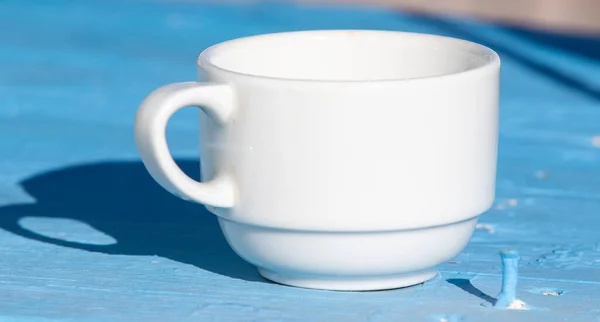 在街上的桌子上摆放着一个手工茶碟的白色茶杯 — 图库照片