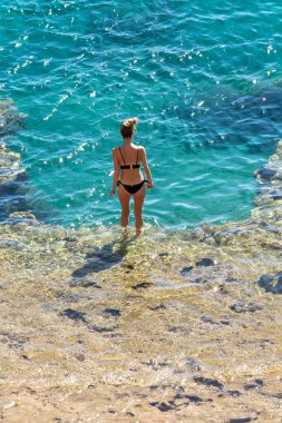 Deniz suyunda mayo giymiş dikiz manzaralı kız. Yaz plajı, deniz manzarası..