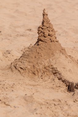 Kumla oynamak ve deniz kıyısında bir kumdan kale yapmak. Sudaki kumdan kale. Kumsaldaki kumdan kale.