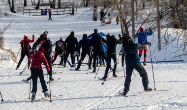 Petropavlovsk, Kazakistan - 29 Şubat 2020: Erkekler ve kadınlar, çocuklar kışın ormanda kayak yapıyor. Güneşli kış manzarası, kayak. Petropavlovsk, Kazakistan.