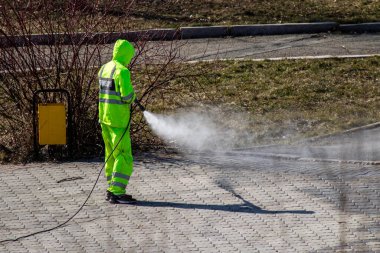 Petropavlovsk, Kazakistan - 11 Nisan 2020: Covid-19 virüsünün ortaya çıkmasıyla bağlantılı olarak şehir merkezindeki sokak ve sokakların temizlenmesi, temizlenmesi ve dezenfekte edilmesi. Koruyucu elbiseli takım.