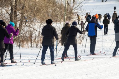 Petropavlovsk, Kazakistan - 29 Şubat 2020: Erkekler ve kadınlar, çocuklar kışın ormanda kayak yapıyor. Güneşli kış manzarası, kayak. Petropavlovsk, Kazakistan.