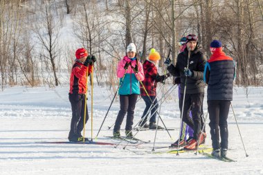 Petropavlovsk, Kazakistan - 29 Şubat 2020: Erkekler ve kadınlar, çocuklar kışın ormanda kayak yapıyor. Güneşli kış manzarası, kayak. Petropavlovsk, Kazakistan.