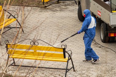 Petropavlovsk, Kazakistan - 12 Nisan 2020: koruyucu elbiseli bir takım. Covid-19 virüsünün ortaya çıkmasıyla bağlantılı olarak şehir merkezindeki sokakların temizlenmesi, temizlenmesi ve dezenfekte edilmesi.
