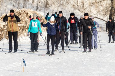 Petropavlovsk, Kazakistan - 29 Şubat 2020: Erkekler ve kadınlar, çocuklar kışın ormanda kayak yapıyor. Güneşli kış manzarası, kayak. Petropavlovsk, Kazakistan.