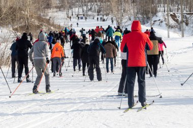 Petropavlovsk, Kazakistan - 29 Şubat 2020: Erkekler ve kadınlar, çocuklar kışın ormanda kayak yapıyor. Güneşli kış manzarası, kayak. Petropavlovsk, Kazakistan.