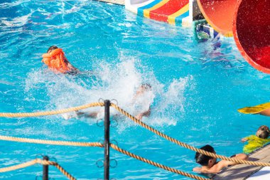 Sharm El Sheikh, Mısır - 28 Ocak 2020: Yetişkinler ve çocuklar havuzda yüzer, güneşli bir günde slaytlara binerler. Başka bir deyişle, seyahat, tatil kavramı..