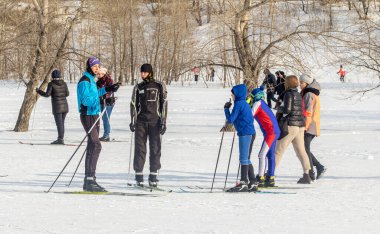 Petropavlovsk, Kazakistan - 29 Şubat 2020: Erkekler ve kadınlar, çocuklar kışın ormanda kayak yapıyor. Güneşli kış manzarası, kayak. Petropavlovsk, Kazakistan.