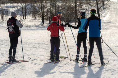 Petropavlovsk, Kazakistan - 29 Şubat 2020: Erkekler ve kadınlar, çocuklar kışın ormanda kayak yapıyor. Güneşli kış manzarası, kayak. Petropavlovsk, Kazakistan.