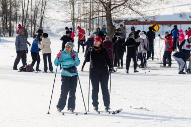 Petropavlovsk, Kazakistan - 29 Şubat 2020: Erkekler ve kadınlar, çocuklar kışın ormanda kayak yapıyor. Güneşli kış manzarası, kayak. Petropavlovsk, Kazakistan.