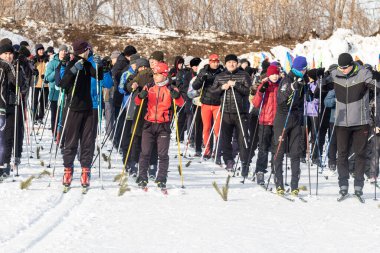 Petropavlovsk, Kazakistan - 29 Şubat 2020: Erkekler ve kadınlar, çocuklar kışın ormanda kayak yapıyor. Güneşli kış manzarası, kayak. Petropavlovsk, Kazakistan.