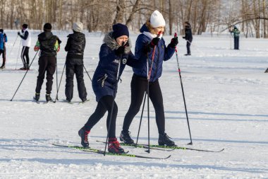 Petropavlovsk, Kazakistan - 29 Şubat 2020: Erkekler ve kadınlar, çocuklar kışın ormanda kayak yapıyor. Güneşli kış manzarası, kayak. Petropavlovsk, Kazakistan.