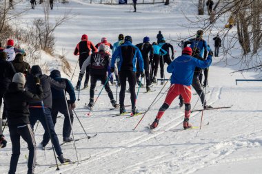 Petropavlovsk, Kazakistan - 29 Şubat 2020: Erkekler ve kadınlar, çocuklar kışın ormanda kayak yapıyor. Güneşli kış manzarası, kayak. Petropavlovsk, Kazakistan.