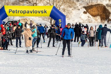 Petropavlovsk, Kazakistan - 29 Şubat 2020: Erkekler ve kadınlar, çocuklar kışın ormanda kayak yapıyor. Güneşli kış manzarası, kayak. Petropavlovsk, Kazakistan.