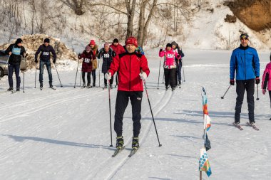 Petropavlovsk, Kazakistan - 29 Şubat 2020: Erkekler ve kadınlar, çocuklar kışın ormanda kayak yapıyor. Güneşli kış manzarası, kayak. Petropavlovsk, Kazakistan.