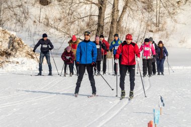 Petropavlovsk, Kazakistan - 29 Şubat 2020: Erkekler ve kadınlar, çocuklar kışın ormanda kayak yapıyor. Güneşli kış manzarası, kayak. Petropavlovsk, Kazakistan.