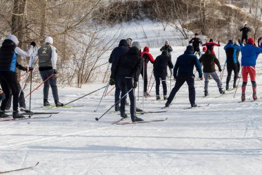 Petropavlovsk, Kazakistan - 29 Şubat 2020: Erkekler ve kadınlar, çocuklar kışın ormanda kayak yapıyor. Güneşli kış manzarası, kayak. Petropavlovsk, Kazakistan.
