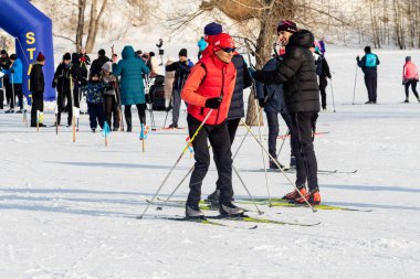 Petropavlovsk, Kazakistan - 29 Şubat 2020: Erkekler ve kadınlar, çocuklar kışın ormanda kayak yapıyor. Güneşli kış manzarası, kayak. Petropavlovsk, Kazakistan.